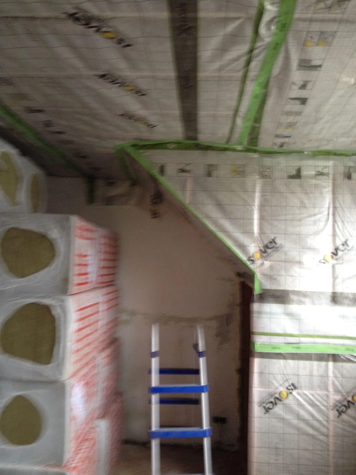 Wanden en plafond met isolatiemateriaal en een ladder in de renovatie