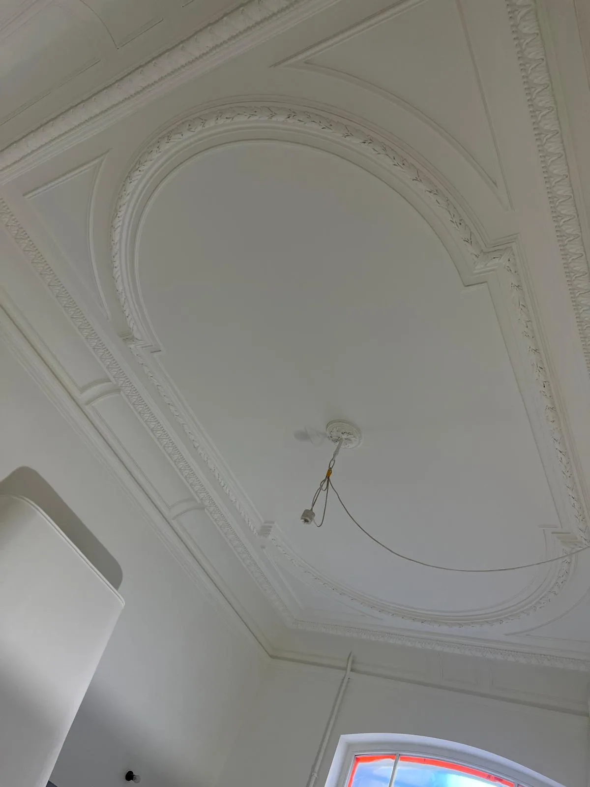Plafond met sierlijst en afwerking in een gerenoveerde ruimte