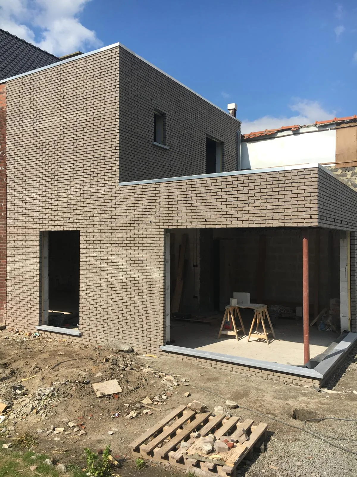 Nieuwe woning in ruwbouwfase met metselwerk en open structuur
