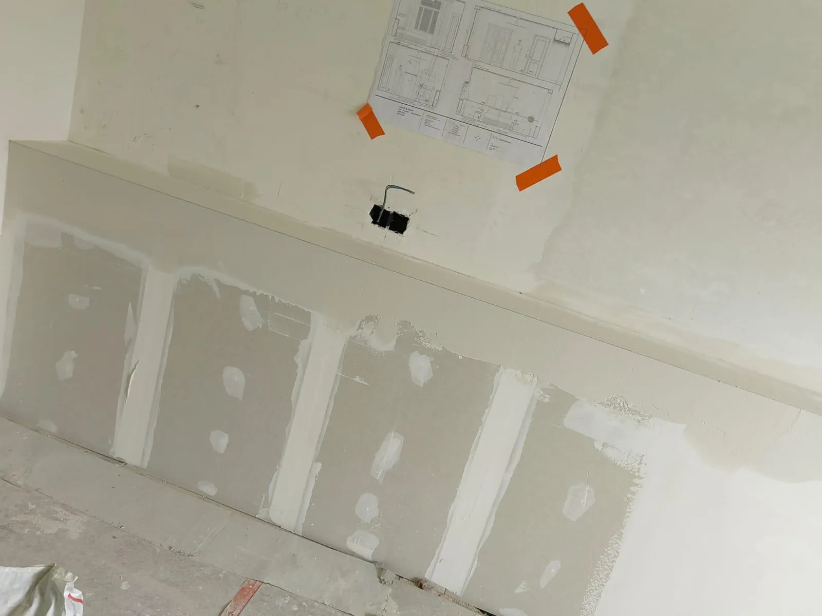 Voorbereiding van binnenpleisterwerk op een muur met elektrische aansluiting