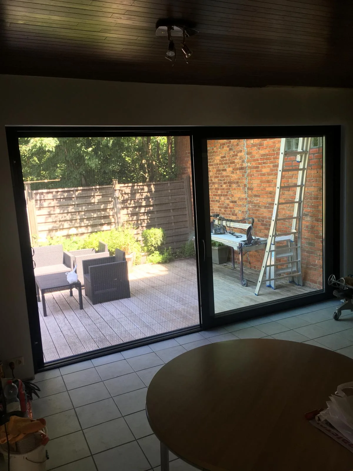 Prachtige glazen schuifdeuren geven toegang tot een houten terras met zithoek