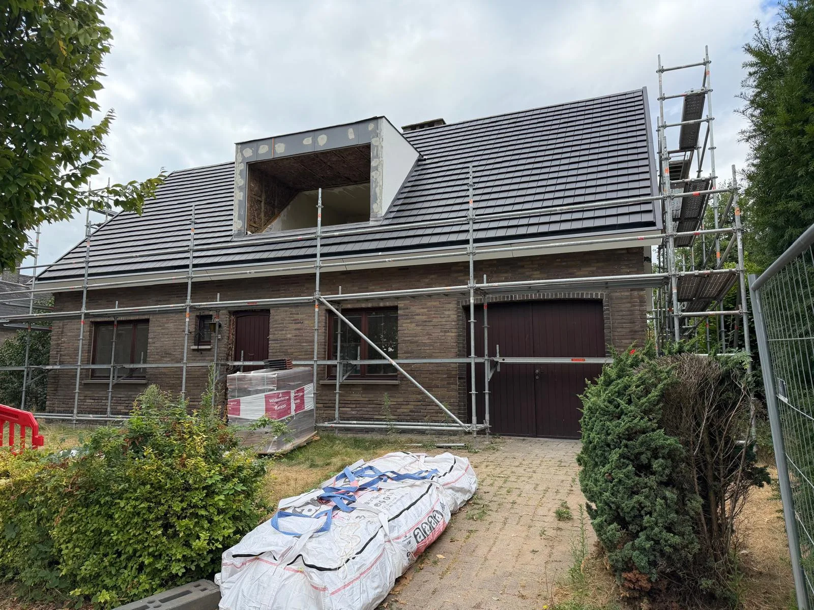 Woningrenovatie met steigers en dakbedekking in een vooruitstrevende fase
