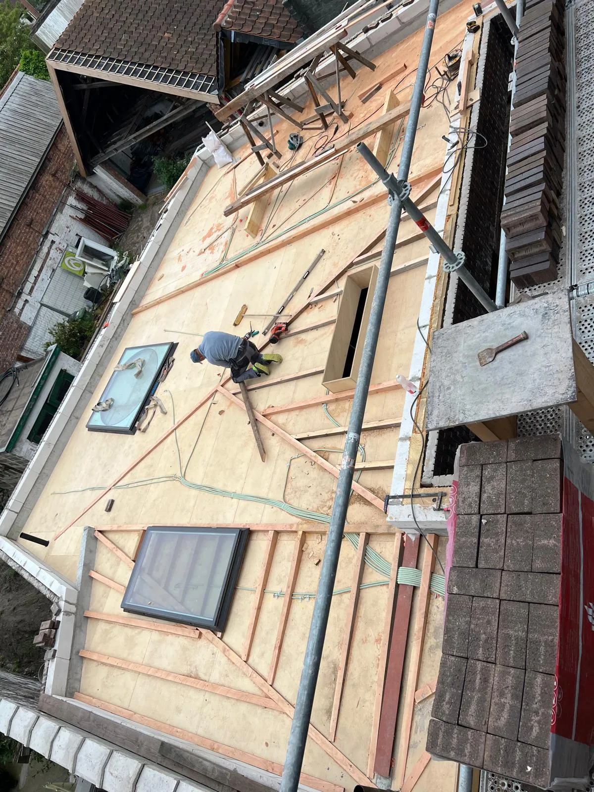 Werknemers aan het werk op een plat dak met nieuwe dakbedekking en isolatie