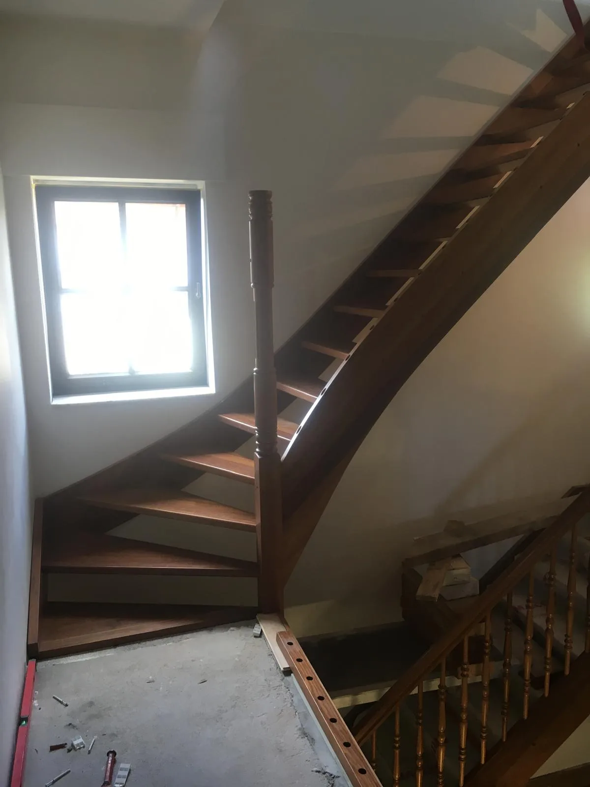 Houten trap met leuning in een huis met natuurlijk licht van een raam