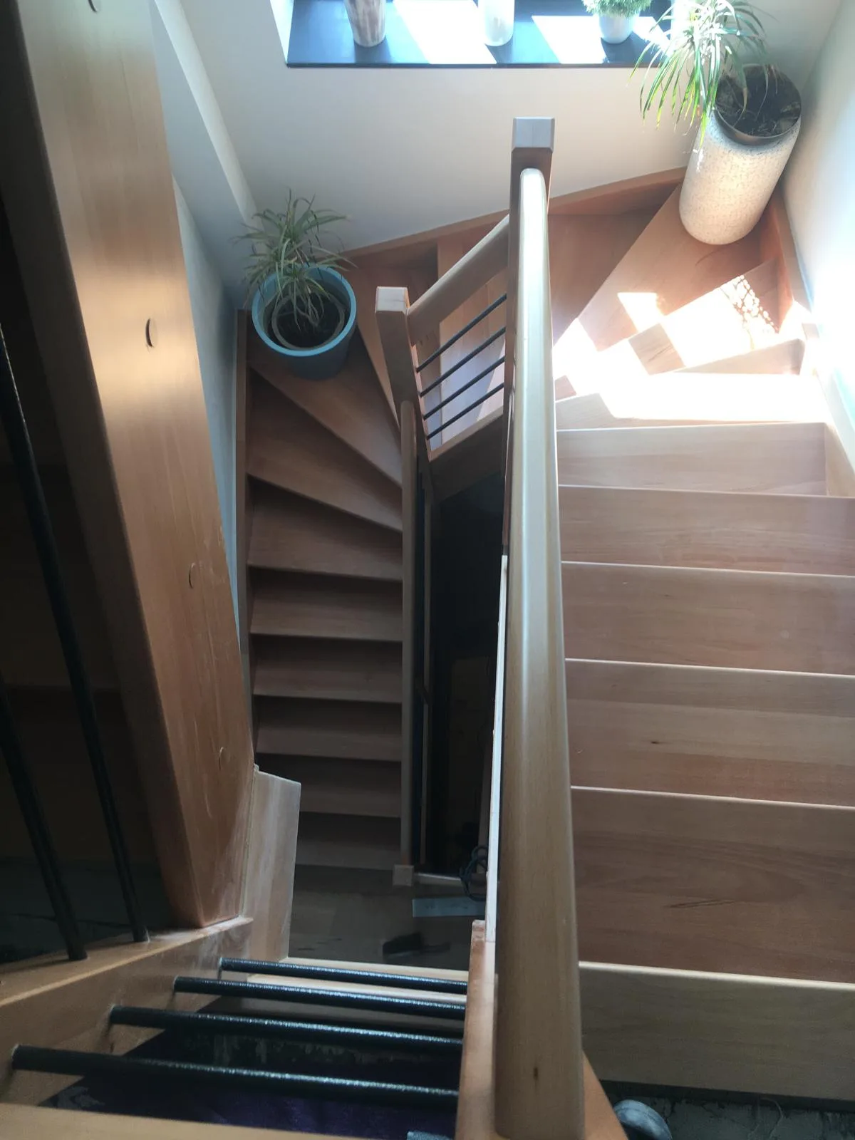 Houten trap met leuning en planten in de achtergrond