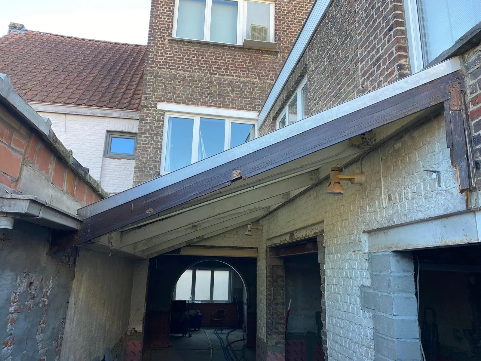 Dakconstructie met houten steunbalken en zichtbare muren voor renovatieproject